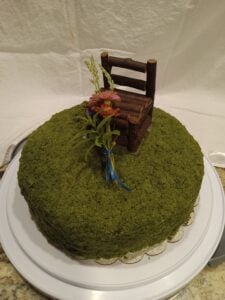 Photo of stinging nettle birthday cake with small bunch of flowers and lemon verbena