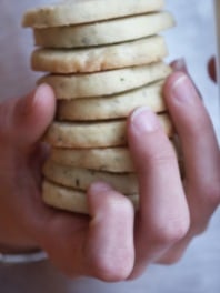 A hand holding a stack of butter cookies