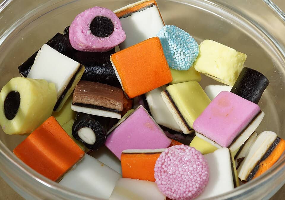 Colorful assorted candies in a glass bowl for herbal and natural remedies.