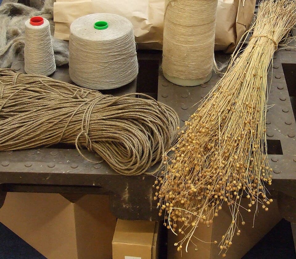 Spools of natural twine and dried herbs on a workbench for craft projects.