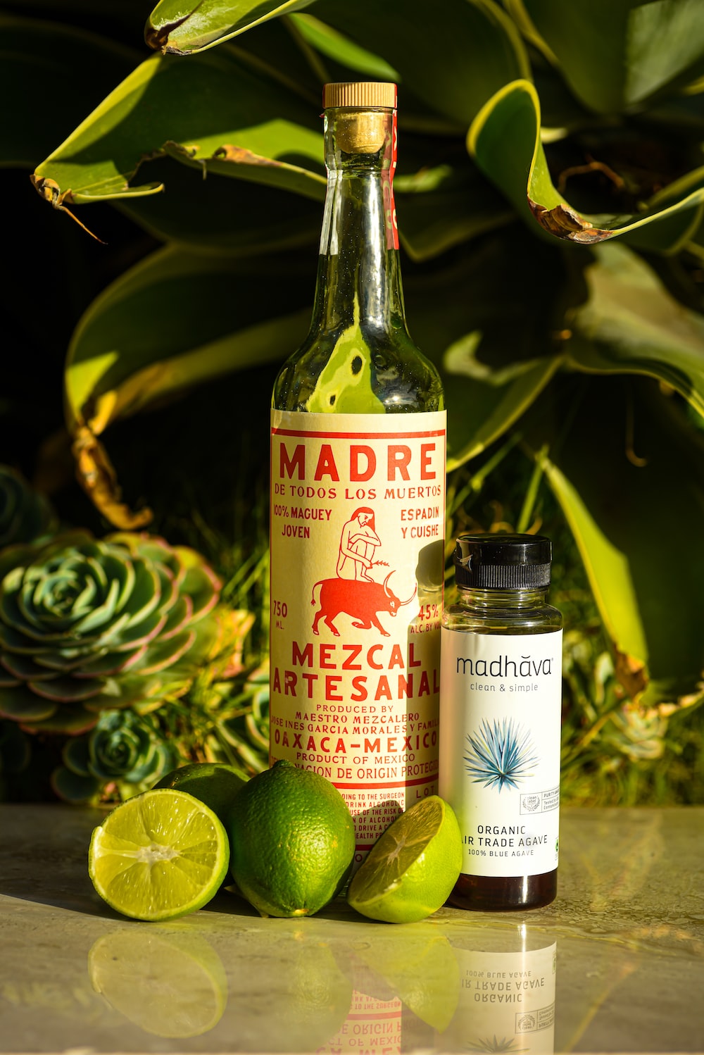 A bottle of Madre mezcal with a trio of limes