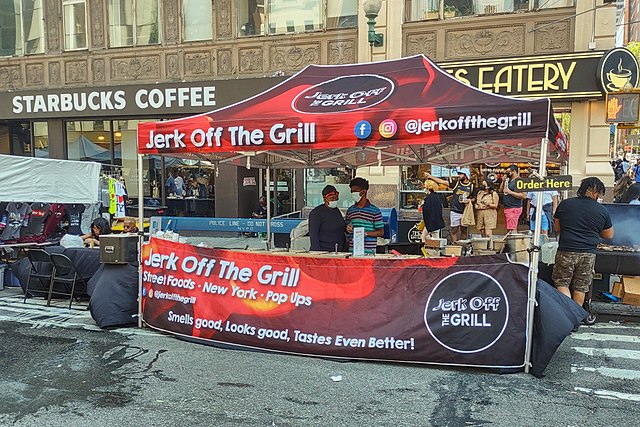 A food tent of Jerk Off The Grill on a street