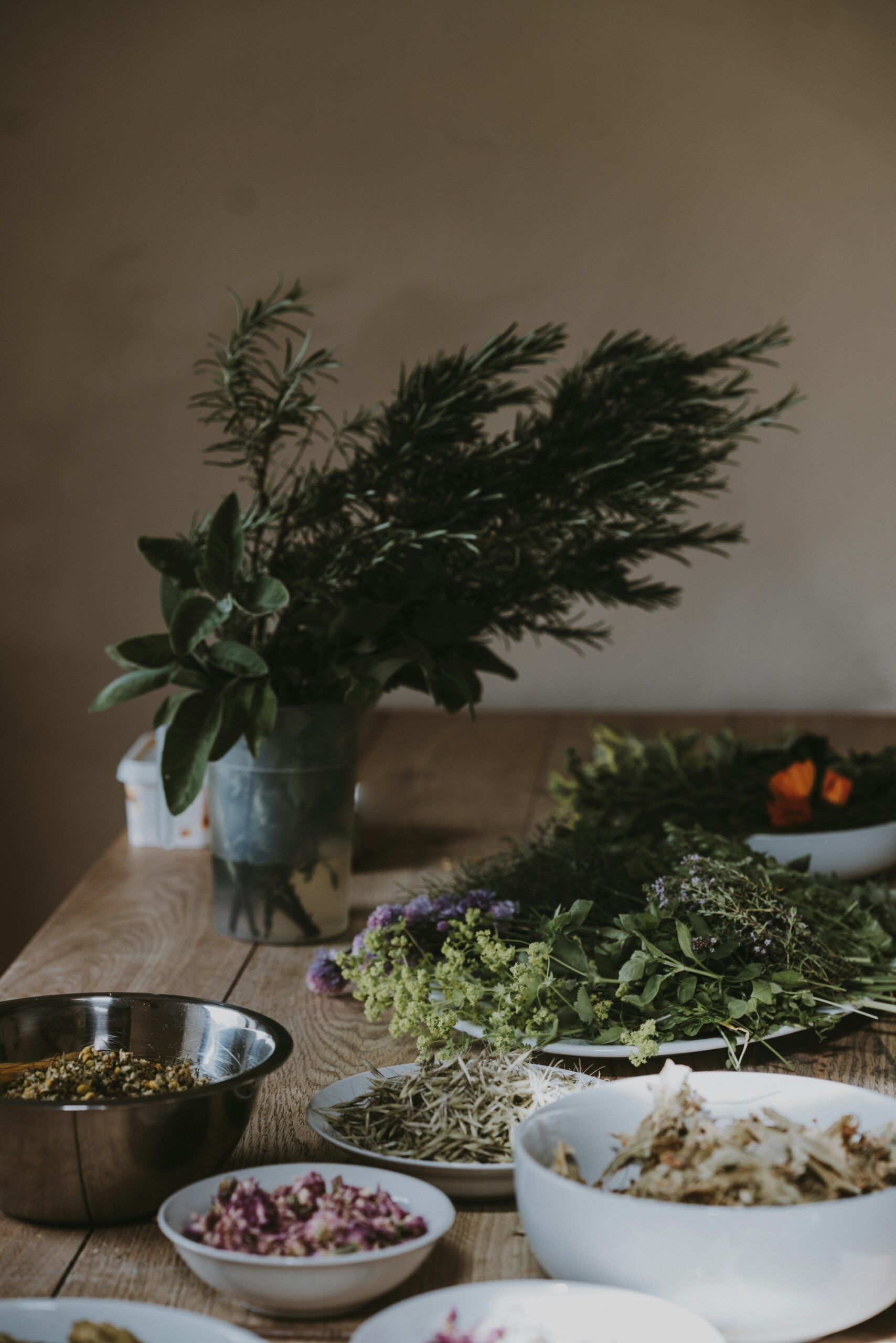 A table set with dishes filled with fresh herbs