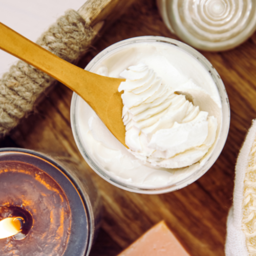 Bowl of body butter and a candle
