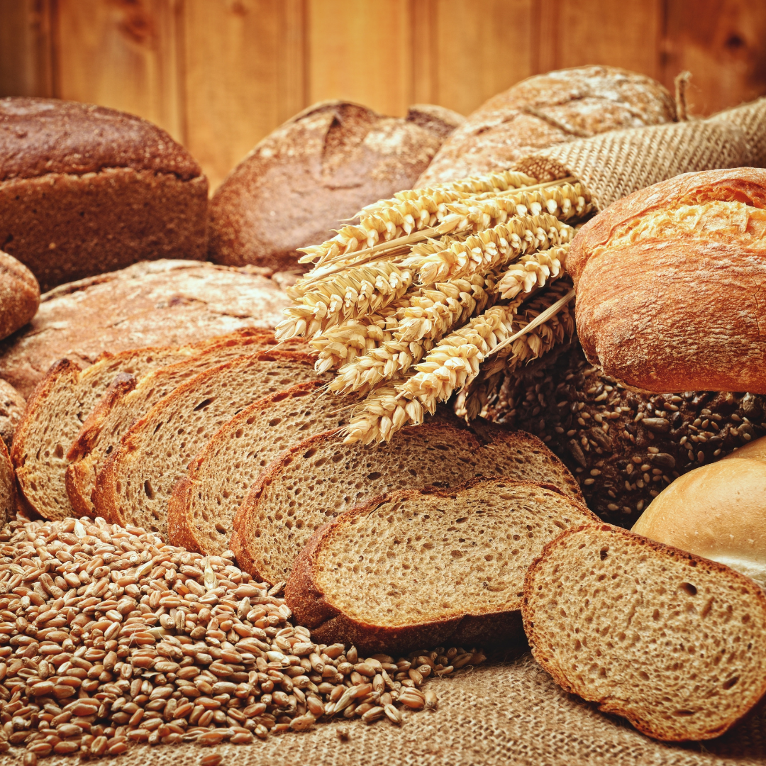 Loaves of bread, piles of grain, and a sheaf of wheat