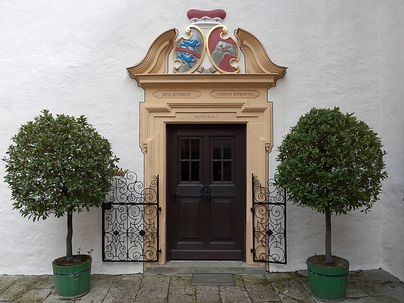 Round-pruned laurel trees flanking a doorway at Greifenstein Castle