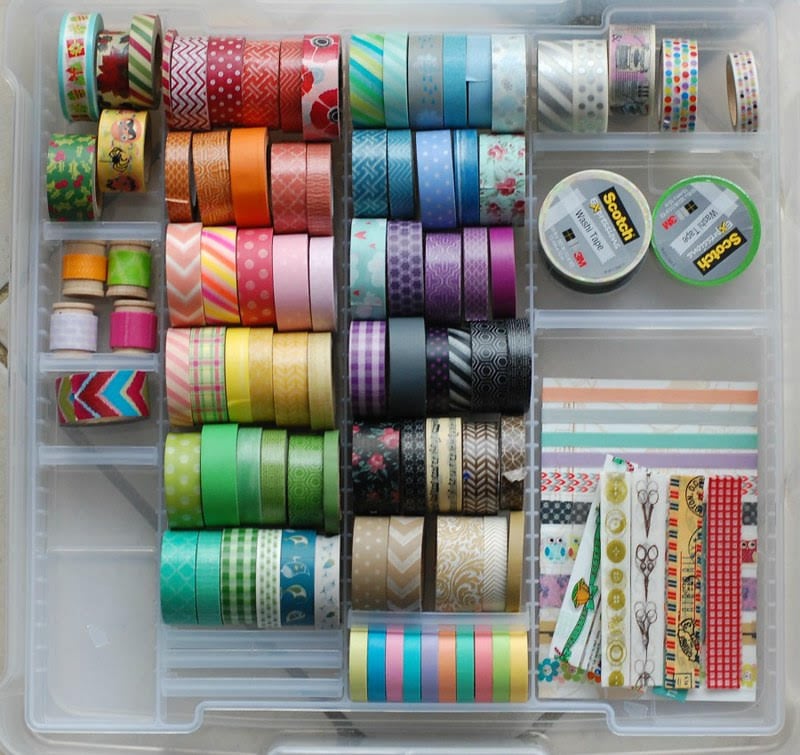 A clear box of colorful washi tape and other craft supplies
