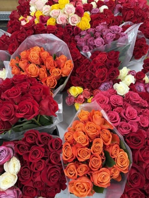 Various vibrant rose bouquets in red, pink, orange, yellow, and white colors.