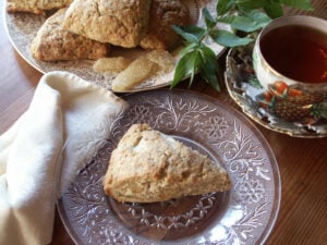 Maple lemon verbena scone cooling on plate with cup of tea